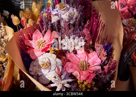 Close-up of a vibrant pink and purple dried flower bouquet with shiny decorative elements. Stylish everlasting floral arrangement for a gift. Stock Photo
