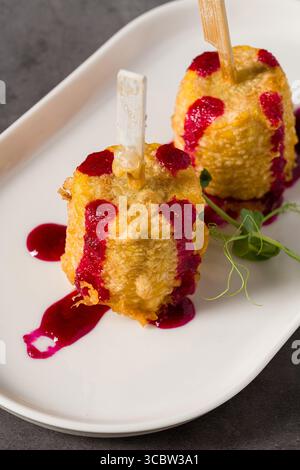 Deep-fried corn tempura on sticks with beetroot puree and microgreens Stock Photo