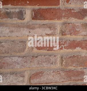 Close-up of weathered red brick wall with mortar lines Stock Photo