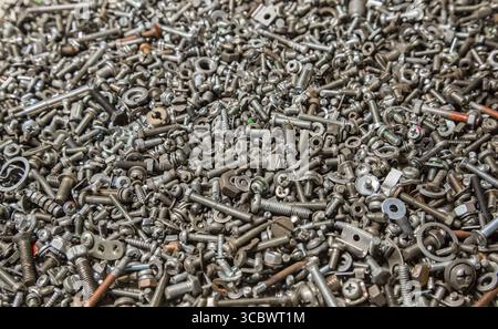Many different small bolts, nuts, washers, grovers, studs and screws. Technical background. Industrial texture. Stock Photo