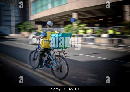 London, UK. 9th August 2025. Pictured: A Deliveroo food delivery rider passes the Britannia International Hotel in Canary Wharf currently housing asylum seekers. Food delivery riders from Deliveroo, Just Eat and Uber Eats have been barred from entering a luxury apartment complex near to where protests against asylum seekers have taken place, with management citing media reports that made claims about “undocumented” workers. The food delivery companies rejected the suggestion they employed undocumented couriers. Credit: Guy Corbishley/Ģ����ý Live News Stock Photo