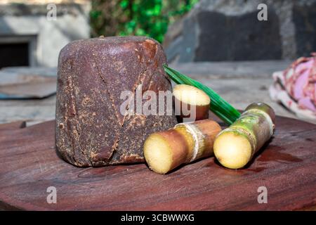 Organic Jaggery ( unrefined sugar ) and sugarcane on wooden background Stock Photo