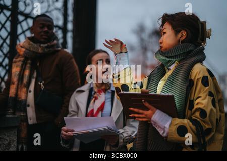 Multiracial people collaborating outdoors with documents Stock Photo