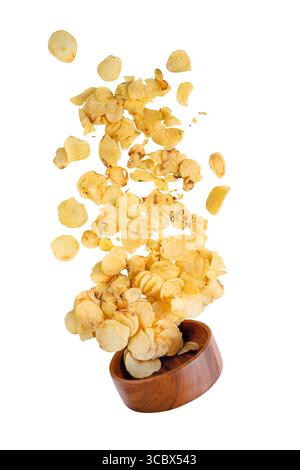 Flying tasty potato chips out of the wooden bowl isolated on white. Falling levitating food. Stock Photo