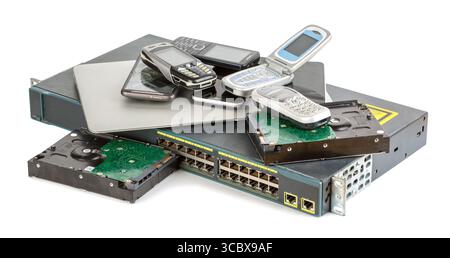 Stack of old and obsolete technic. Laptop, Hard disk drives, old vintage mobile phones isolated on white background. Stock Photo