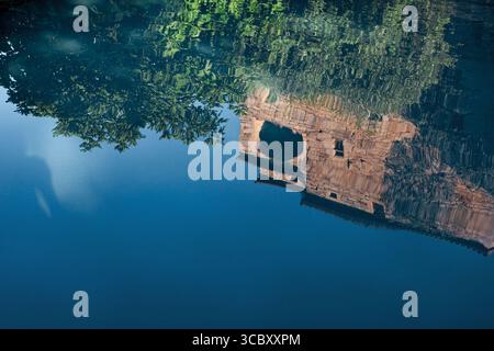 Reflection of a stone house in a swimming pool Stock Photo