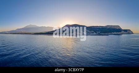Seaside panoramic view of Kiris resort near Kemer, Turkey, with sunset over the majestic Taurus mountain and the deep blue Mediterranean Sea Stock Photo