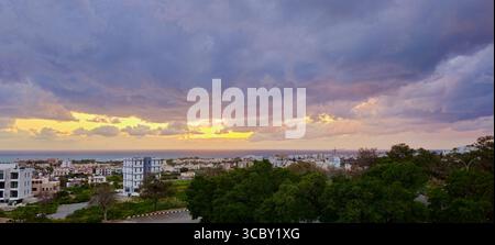 Dramatic Cloudy Sky Over Scenic Coastal Urban Landscape at Sunset Stock Photo