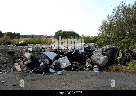 Pile of asphalt and concrete rubble from roiad surface repairs on a rural country roadway Stock Photo