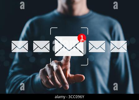 New email notification interaction concept. A person interacting with a floating digital interface showing a new email notification symbol, a concept Stock Photo
