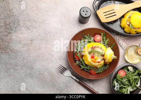 Tasty stuffed pattypan squash with tomatoes and arugula served on grey table, flat lay. Space for text Stock Photo