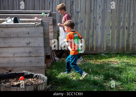 Wheat Ridge, Colorado - Brothers hunt for Easter eggson Easter Sunday in their family's back yard. Stock Photo