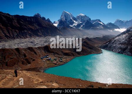 Trekkers climb Gokyo Ri ( Gokyo Peak ) in Nepal - with a backdrop of the third lake of the spectacular Gokyo valley. This valley is increasingly an in Stock Photo