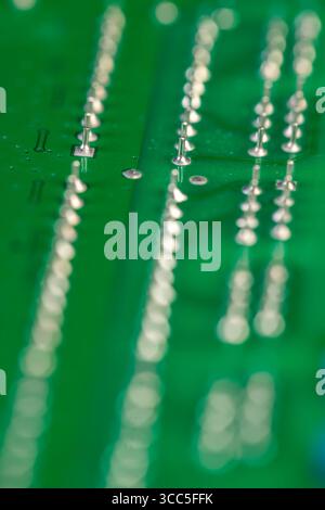 old circuit board with contacts, a simple green printed circuit board with an electronic circuit with soldered elements Stock Photo