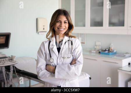 Happy successful doctor woman standing in ultrasound diagnosing room Stock Photo