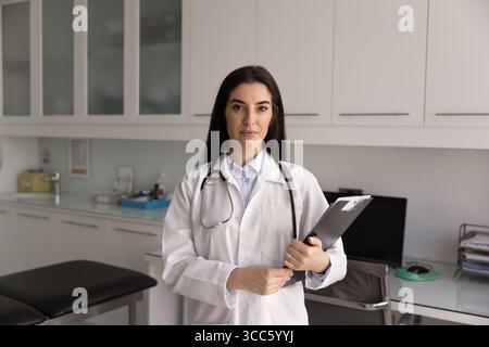 Confident female Latin doctor posing in hospital Stock Photo