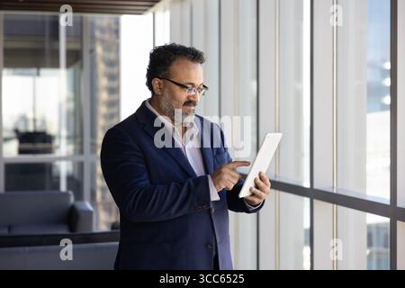 Senior Indian business professional executive man using Internet technology Stock Photo