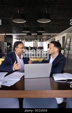 Two diverse male business partners discussing investment for startup Stock Photo