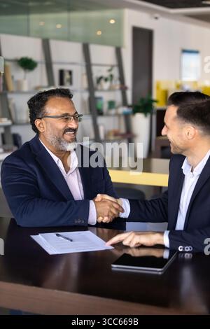 Happy business project buyer and seller men shaking hands Stock Photo