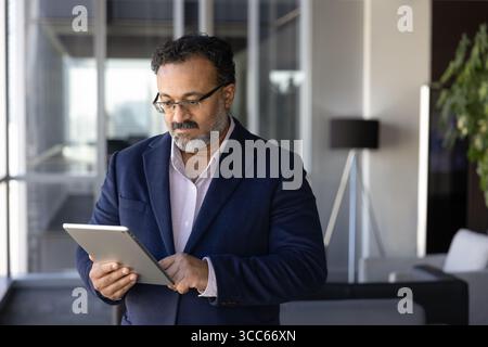 Serious Indian company director man using management application Stock Photo