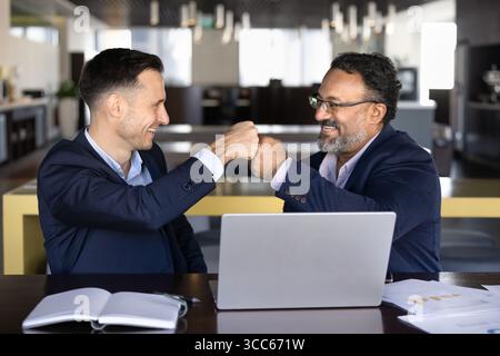 Two happy diverse business colleagues making fist bump hands Stock Photo