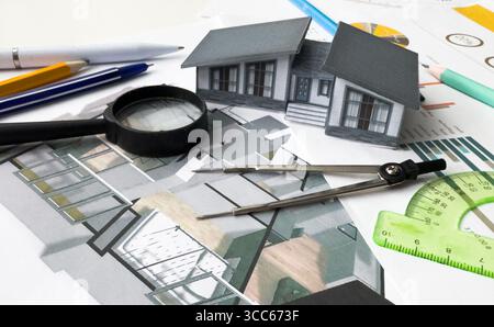 Architects house model with measurement tool and blueprints on architect desk. A architects home model with plan and blueprints. Business Stock Photo