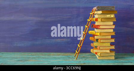 Conceptual image of a stack of books with ladder of success, idea, achievements, education, knowledge,academia and success concept. Stock Photo