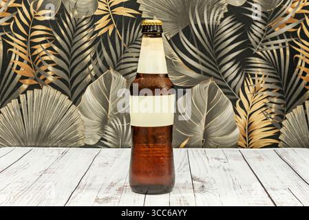 Dark beer bottle with a gold label, showing its deep hue against the light, perfect for a photo that contrasts darkness and elegance Stock Photo