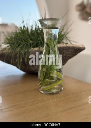 Carafe of mint and lime water on table Stock Photo