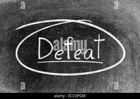 White chalk hand writing in word defeat and circle shape on blackboard background Stock Photo