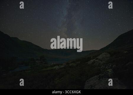 Milky Way and star-filled night sky above Tryfan mountain in Wales Stock Photo