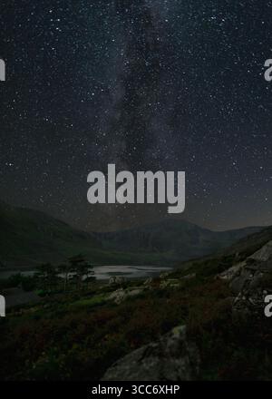 Milky Way and star-filled night sky above Tryfan mountain in Wales Stock Photo