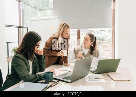 Business colleagues discussing over computer at desk in office Stock Photo