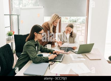 Female business colleagues are working in the office on a joint project. Stock Photo