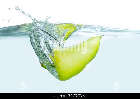 Dynamic splash of a green apple entering clear water, creating bubbles and ripples. Stock Photo