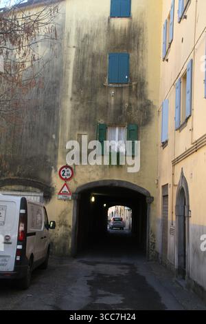 Narrow passageway for vehicles created under a building  in the historical center of Porretta Terme, Italy Stock Photo