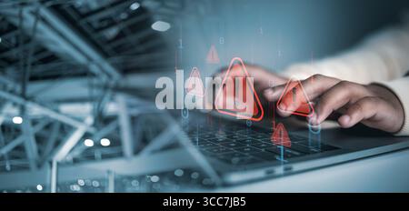 Cyber security concept, Hands typing on laptop with red cybersecurity warning icons overlay, symbolizing data breach, hacking risk, malware attack, an Stock Photo