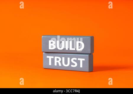 Build Trust written on gray wooden blocks. A symbol of trust in life and business. Conceptual words. Nurturing relationships and good collaboration. B Stock Photo
