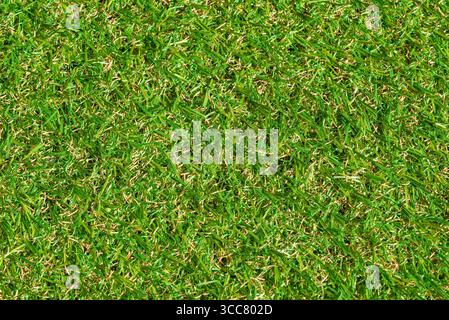Close up of a synthetic green grassy field. The grass is short and the field is lush and green. Full frame backgrounds for sport concepts Stock Photo
