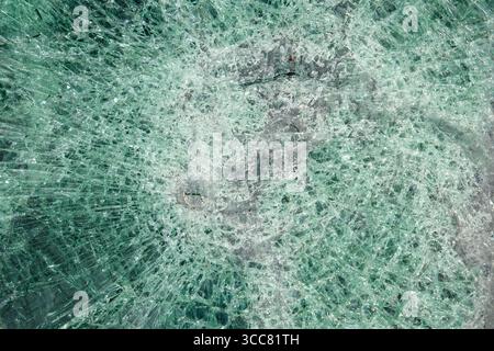 A closeup view of a broken car windshield. The window is completely destroyed. Stock Photo