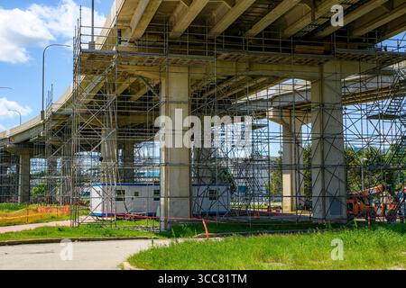 Looking up under a bridge that is under repair. Much steel scaffolding is under the bridge. Stock Photo