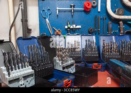 Sets of drills on a table in a workshop. Stock Photo