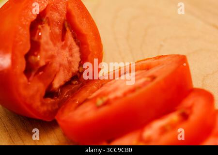 Closeup of Sliced Tomato on Wooden Cutting Board Stock Photo