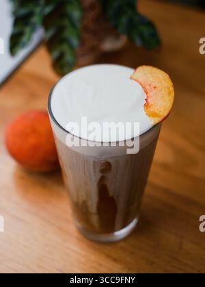 Peach‑Garnished Cold‑Foam Iced Coffee on Wood Stock Photo