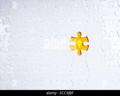 Missing puzzle piece with glowing light bulb icon on yellow background symbolizes finding the right idea, creative solution, problem solving, innovati Stock Photo
