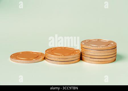 Stacks of golden coins lined up by height from left to right. The coins are arranged in a ascending order, symbolizing financial growth Stock Photo