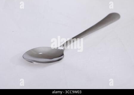 Silver colored spoon isolated on white background. Stock Photo