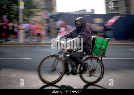 London, UK. 10th August 2025. Pictured: Uber Eats food delivery rider passes anti-migrant protests near the Britannia International Hotel in Canary Wharf currently housing asylum seekers. Food delivery riders from Deliveroo, Just Eat and Uber Eats have been barred from entering a luxury apartment complex near to where protests against asylum seekers have taken place, with management citing media reports that made claims about “undocumented” workers. Credit: Guy Corbishley/Ģ����ý Live News Stock Photo