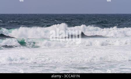 Atlantic surf lines up in breaking sets off Downpatrick Head, County Mayo, Ireland. Whitecaps and turquoise foam filling the frame on a windy day. Stock Photo