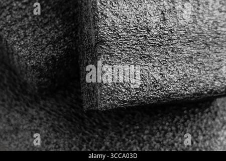 Black foam panel pieces. Abstract geometric composition. Porous material with dark texture. Stock Photo